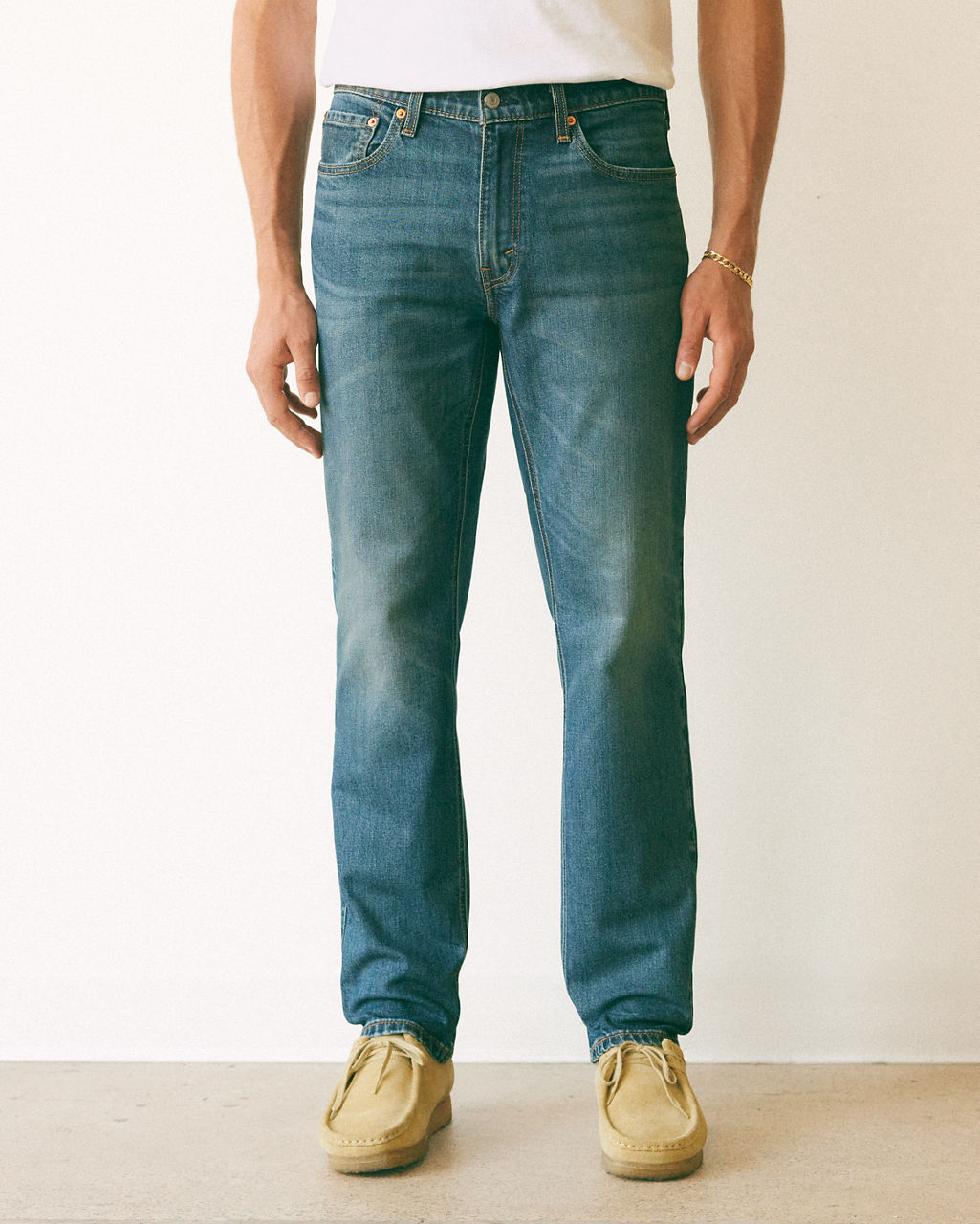 Male model wearing tapered fit jeans.