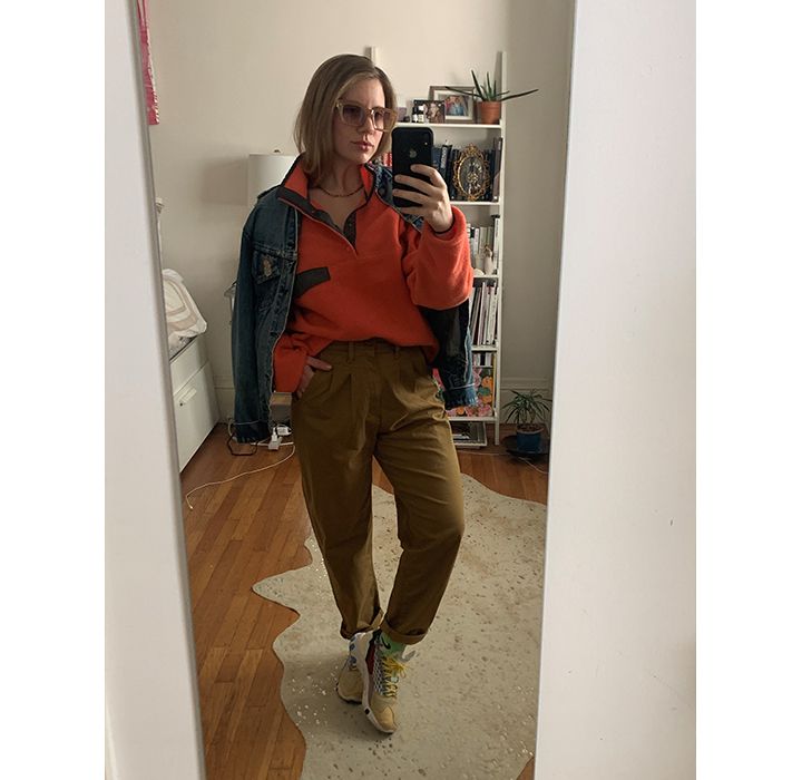 A mirror selfie of Haley Mitgang. She is wearing a red pullover fleece, a Levi's Trucker Jacket, and khaki pleated Balloon pants with sneakers.