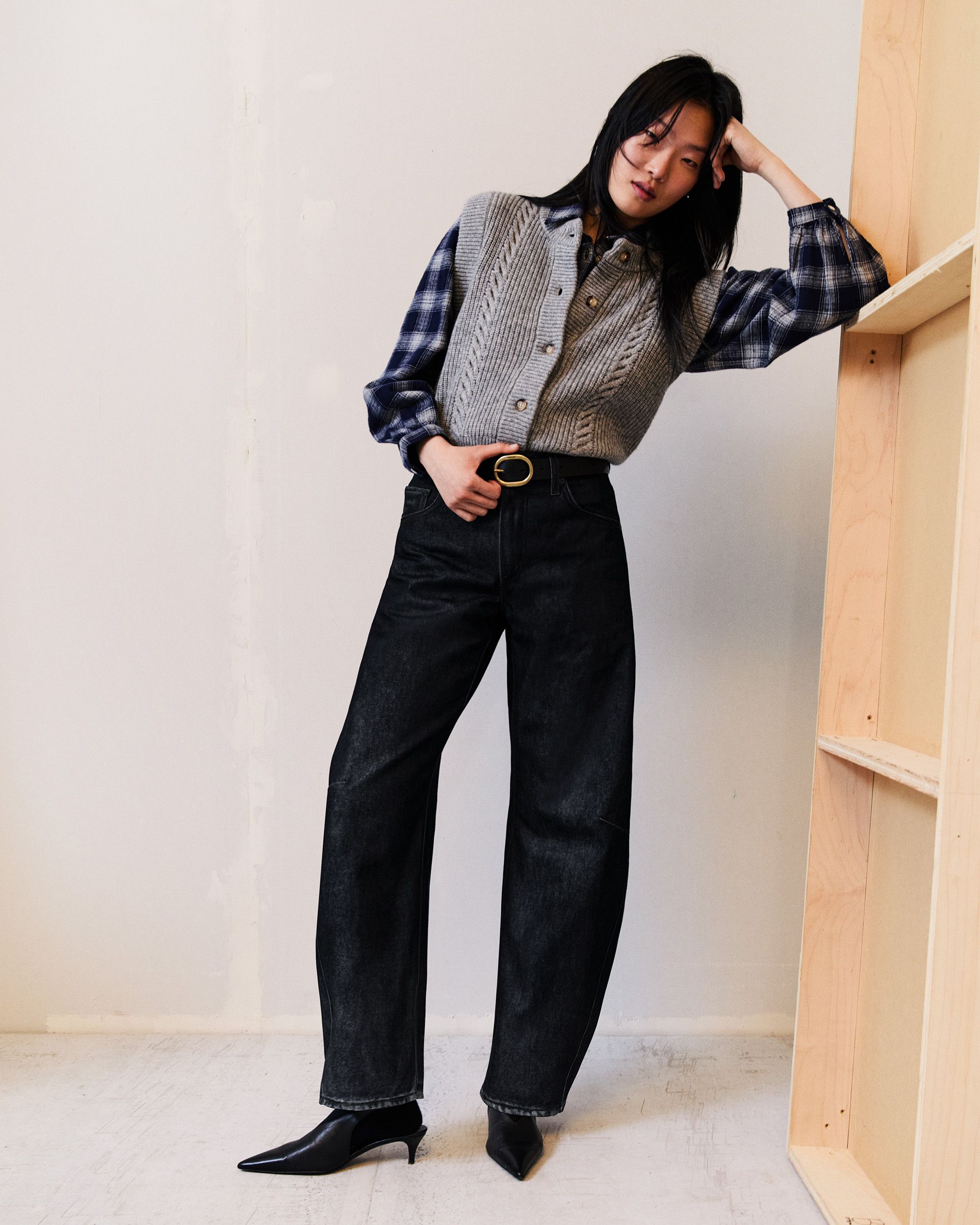 Model in dark wash denim and plaid button up