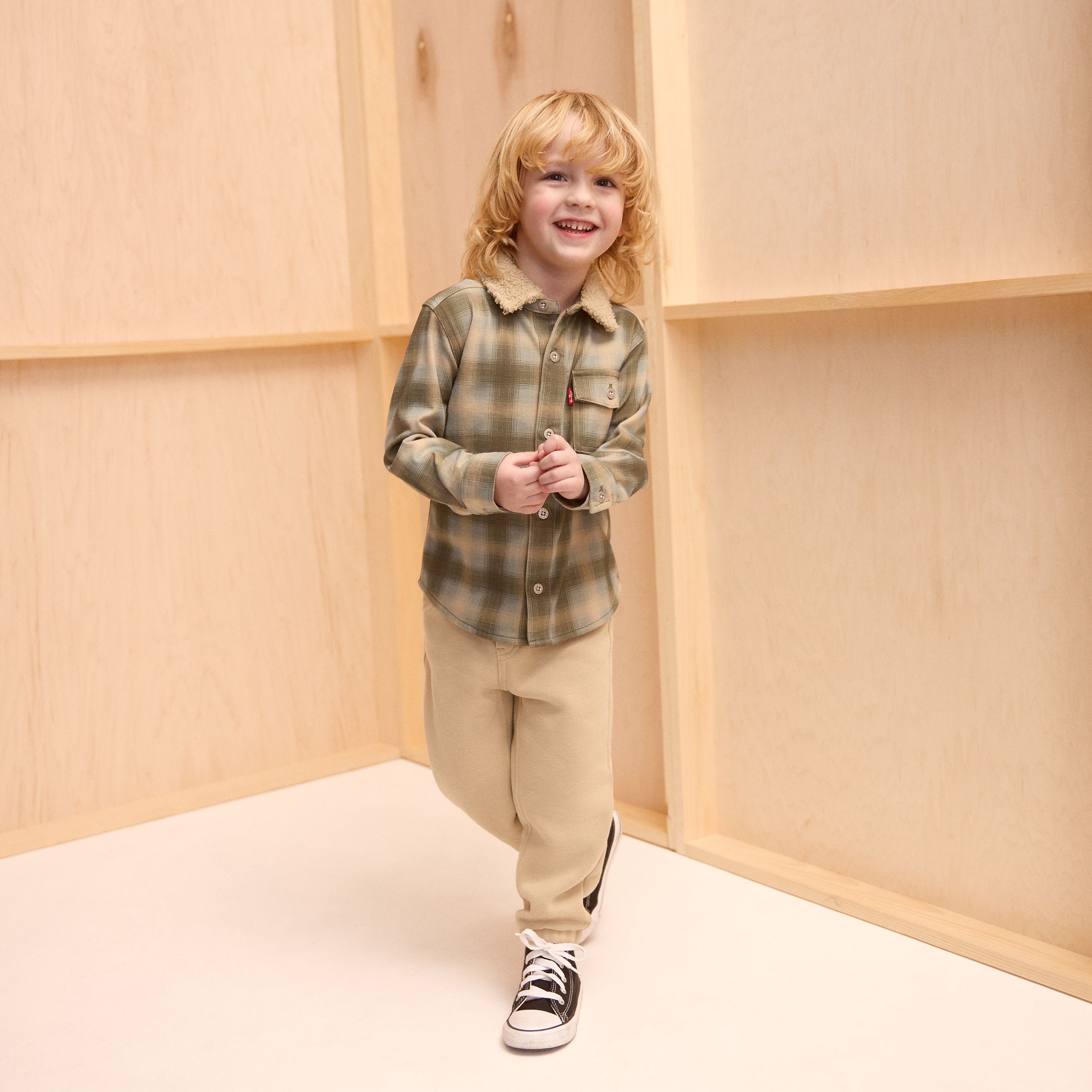 Little boy model wearing shorts and a tee.