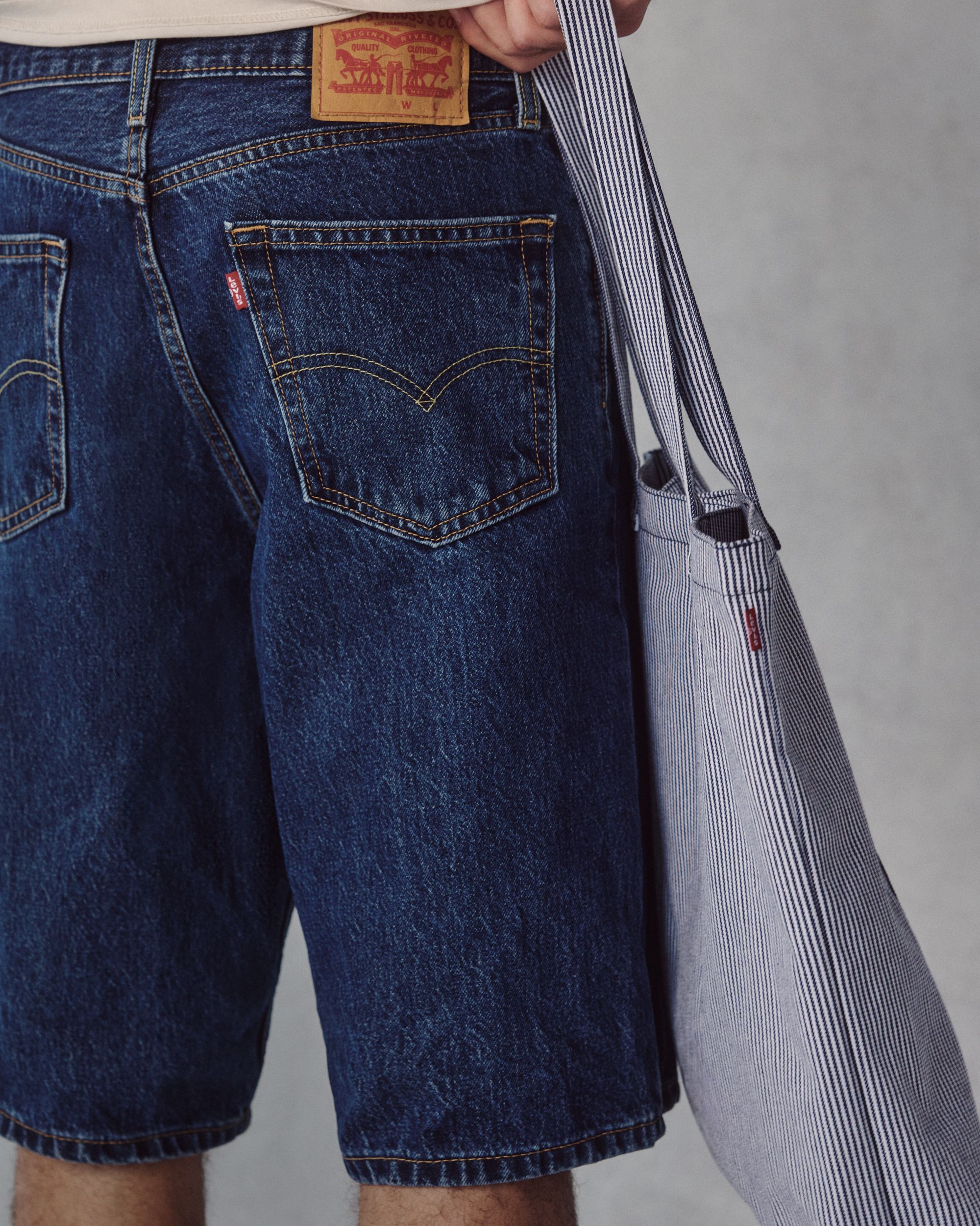 Closeup buttshot of model in long dark denim shorts