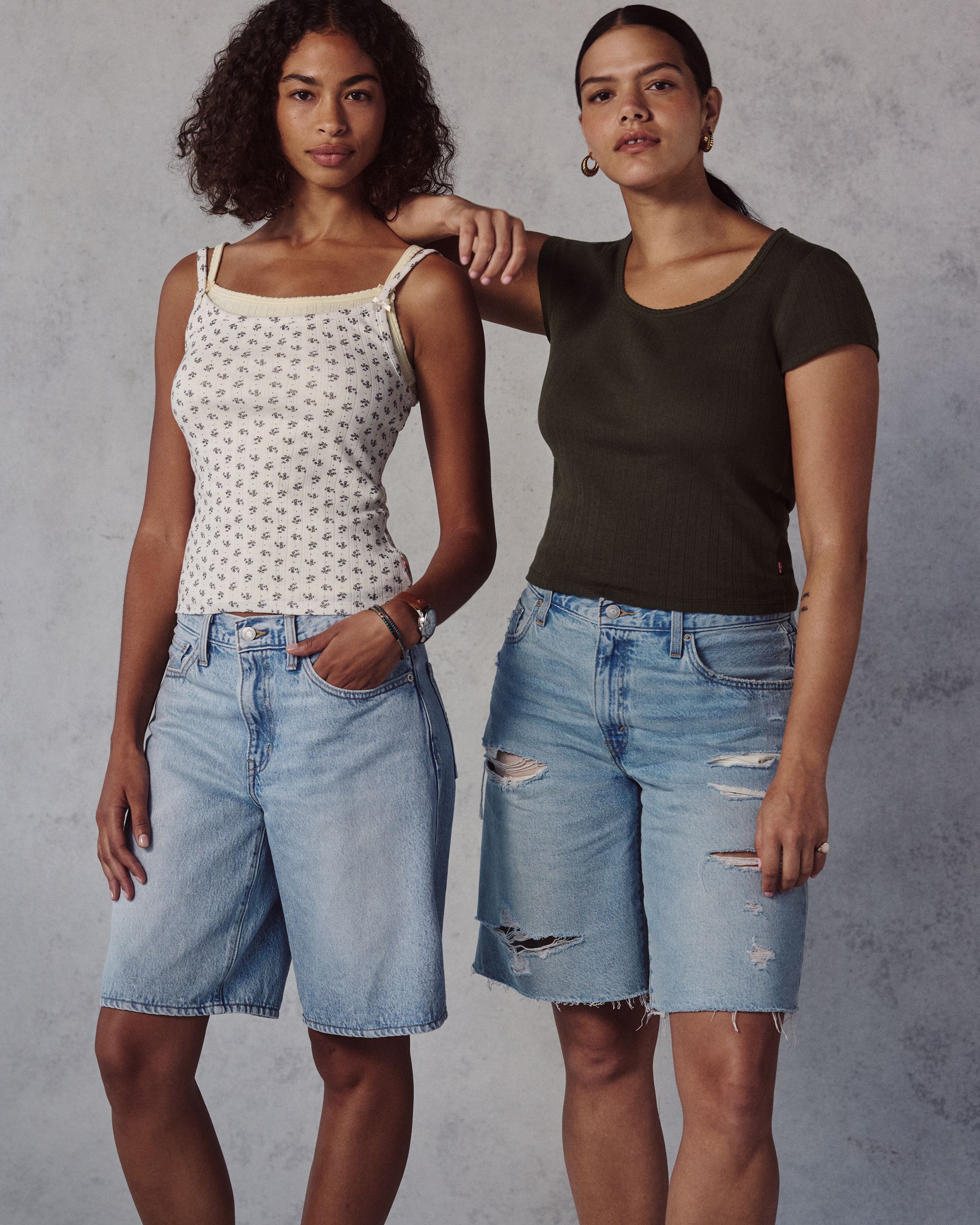 Models in long light wash shorts