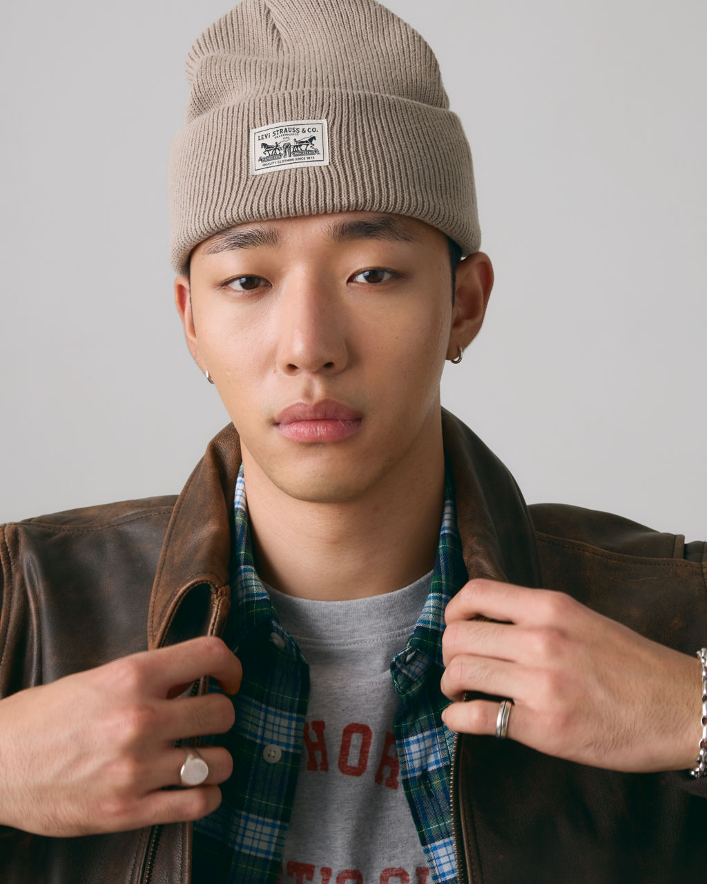 Closeup of model in beige knit logo beanie