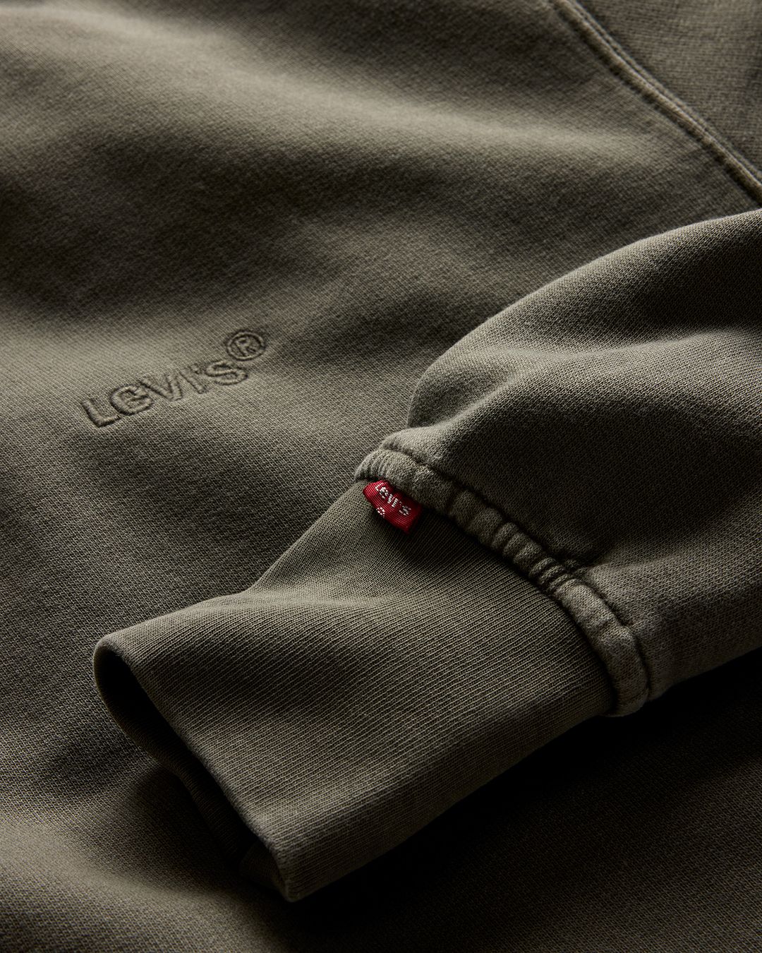 Flat lay closeup of a green garment dyed sweatshirt