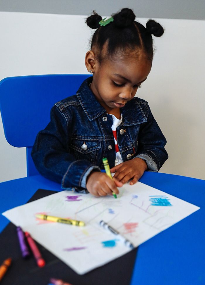 Photo of Emory Walker drawing with crayons. She is wearing a kids Levi's Trucker Jacket.