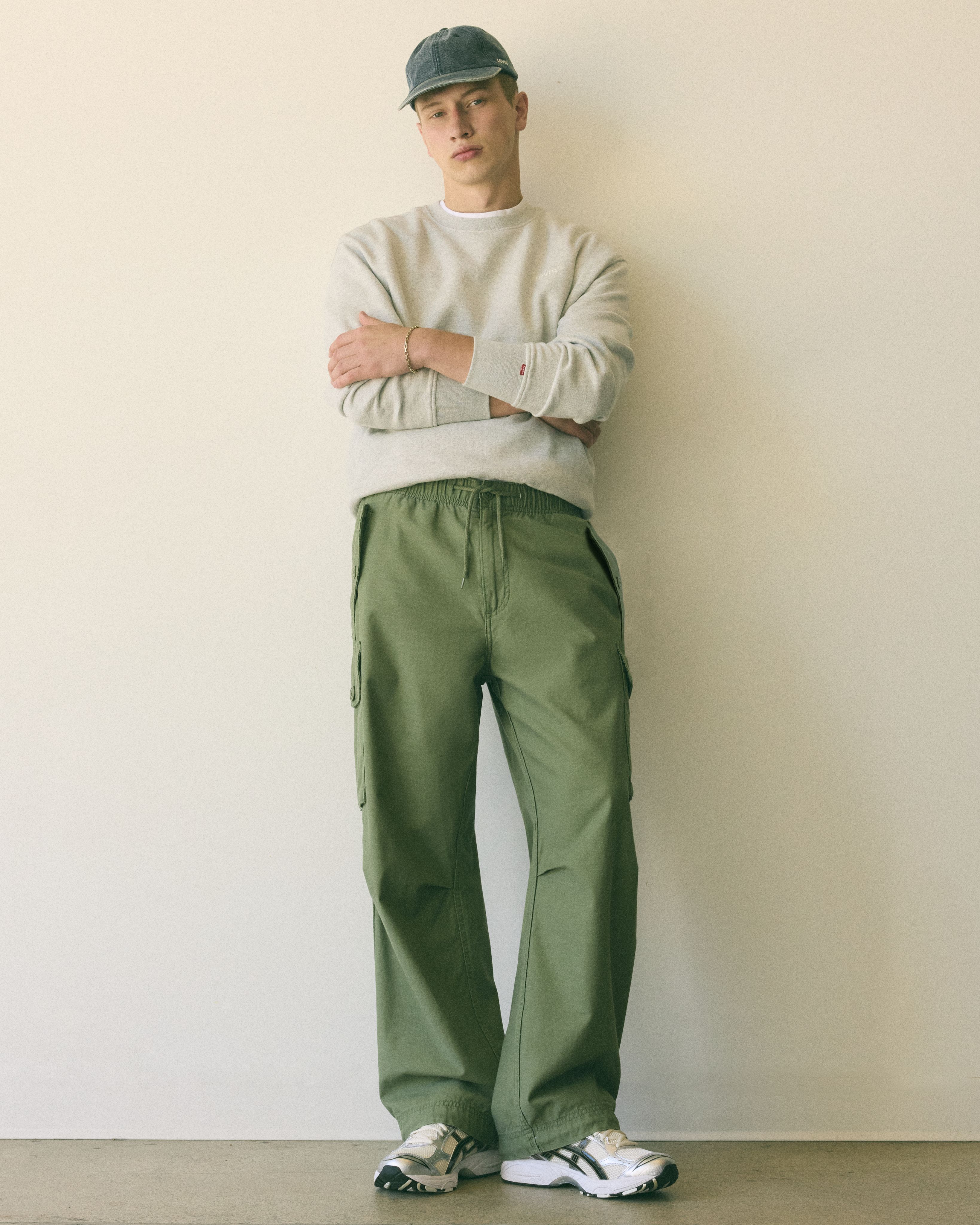 Model wearing tan relaxed fit pants.