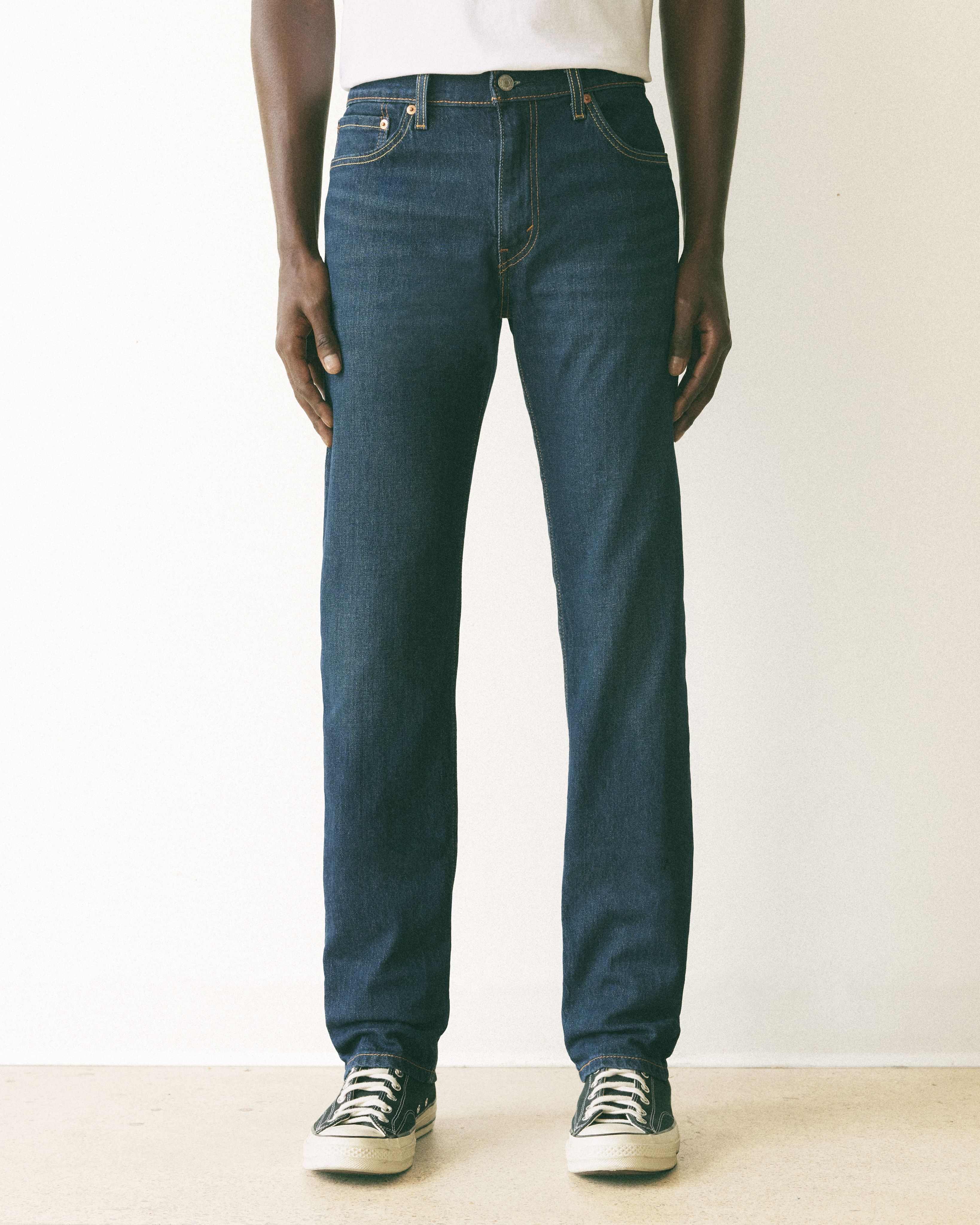 Model wearing tan slim fit pants.