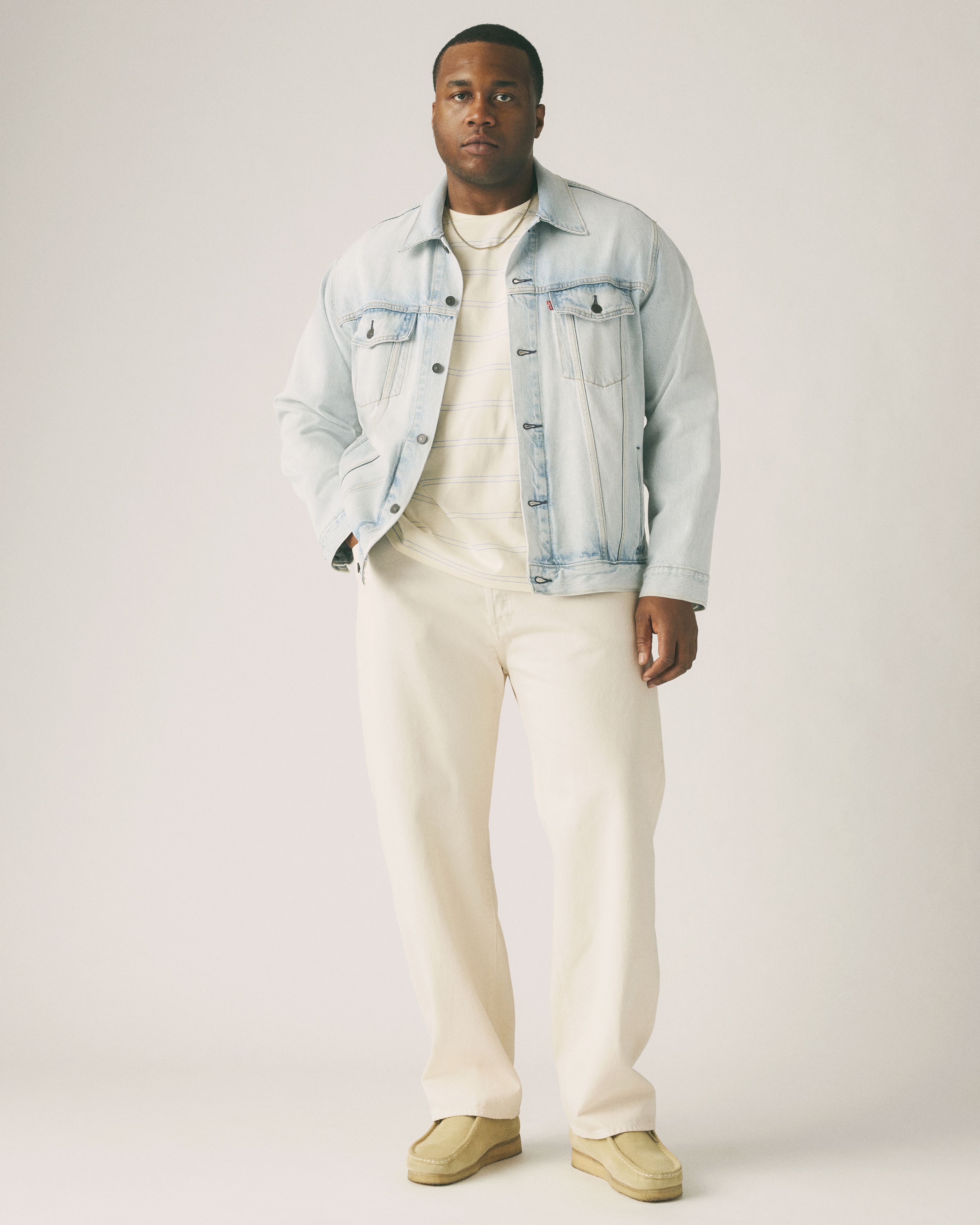 Big & tall male model wearing jean pants and a tee.