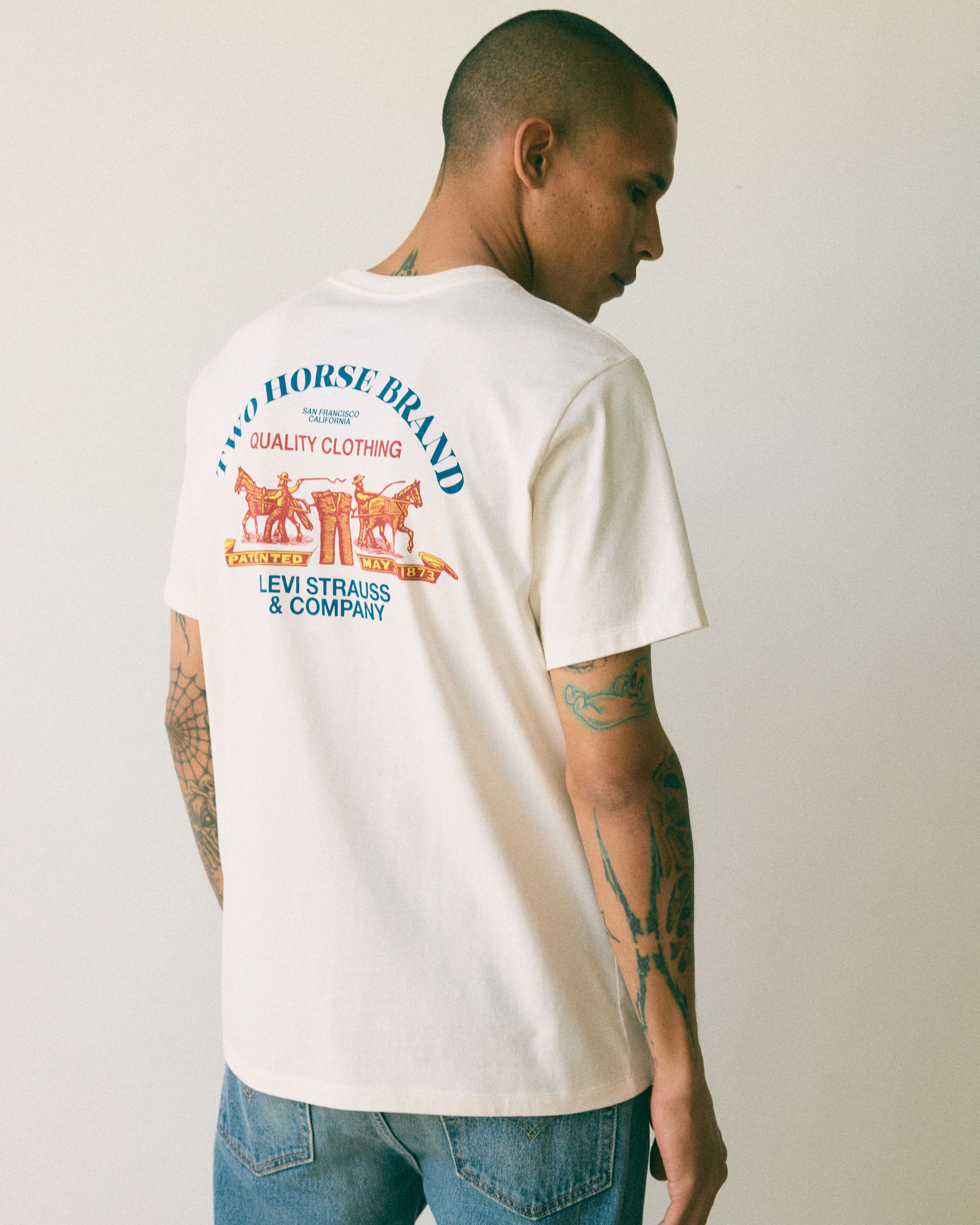 Model wearing white graphic t-shirt.