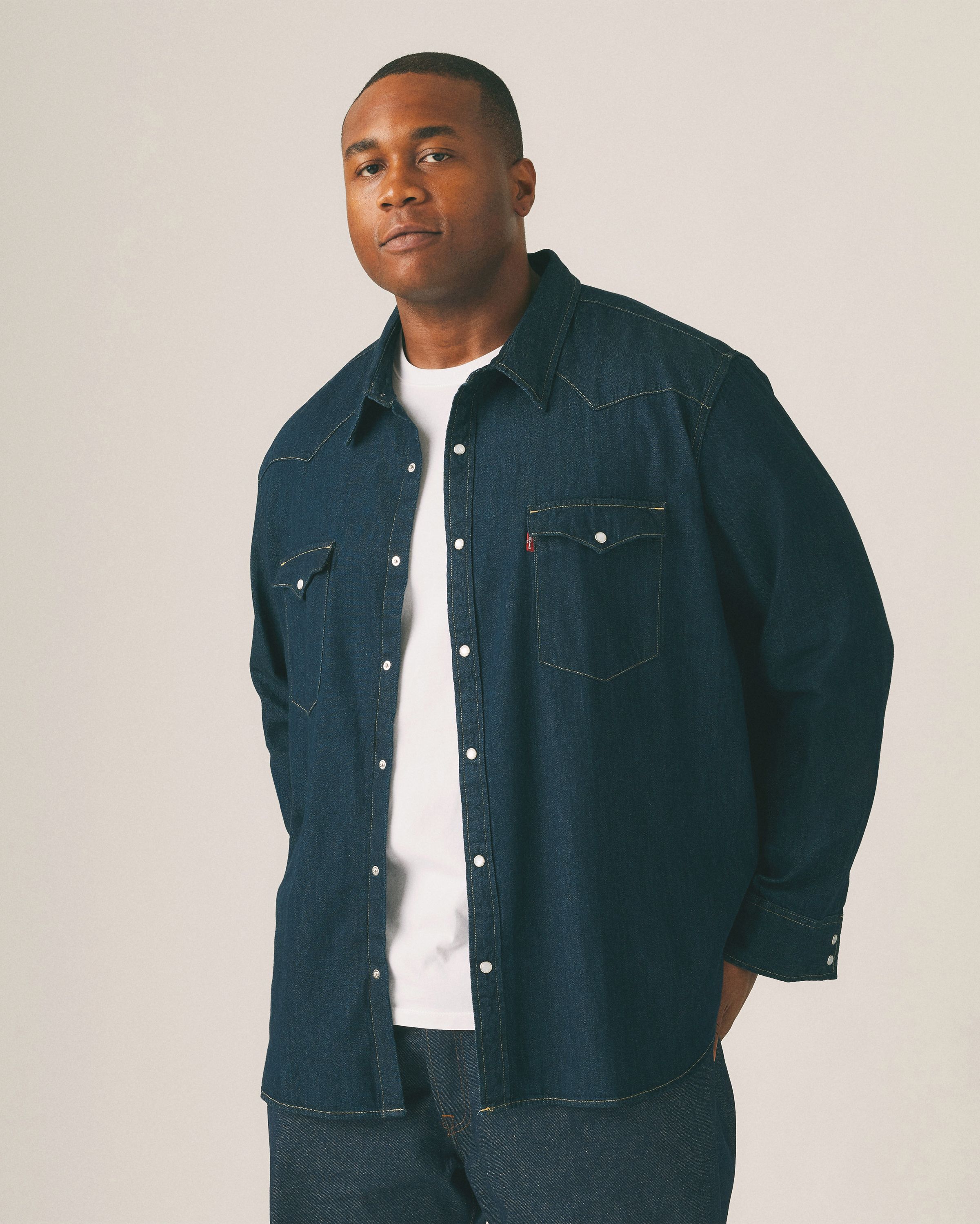 Model wearing black tee with white Levi's logo on the chest.