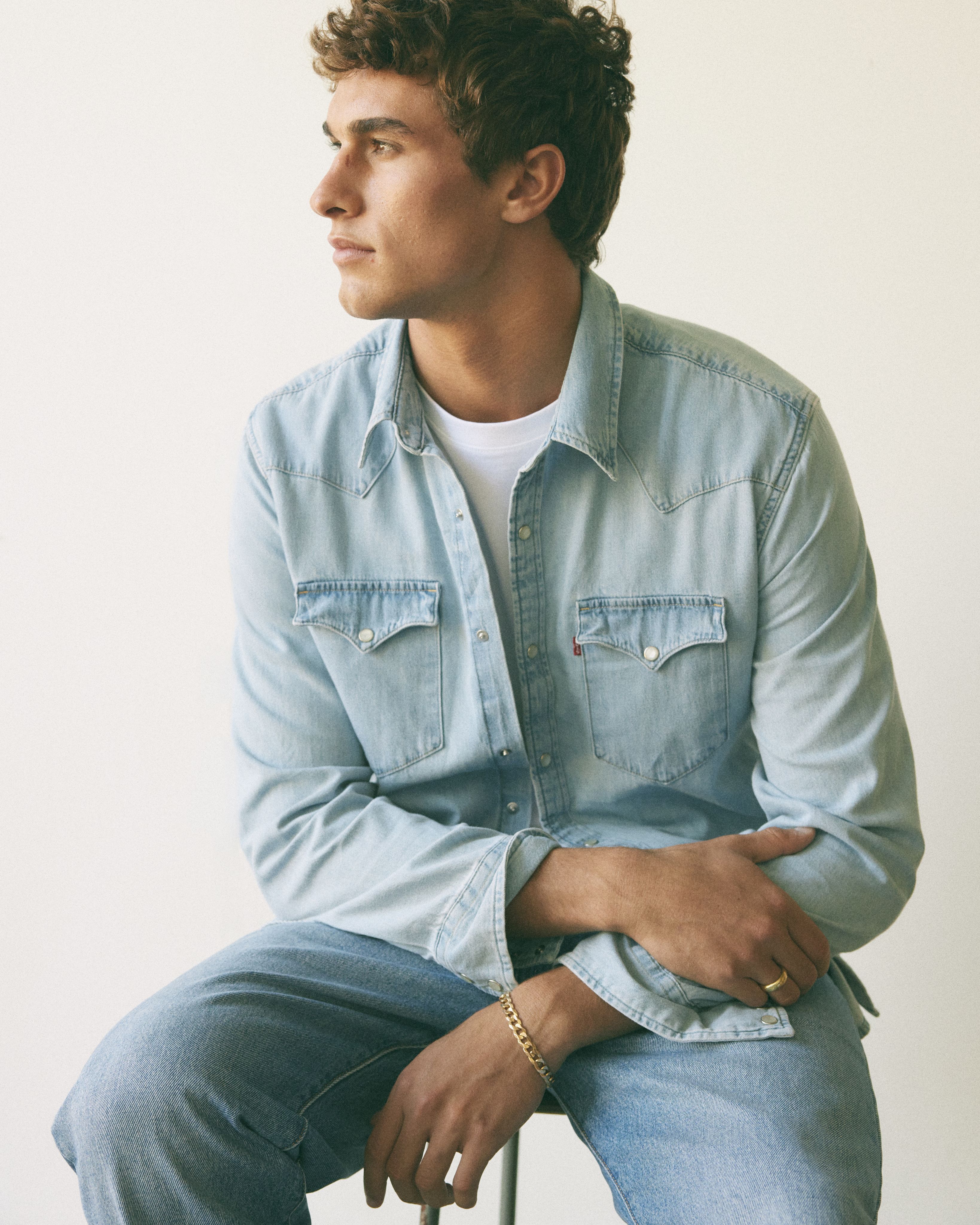 Model wearing light wash denim long-sleeve top.