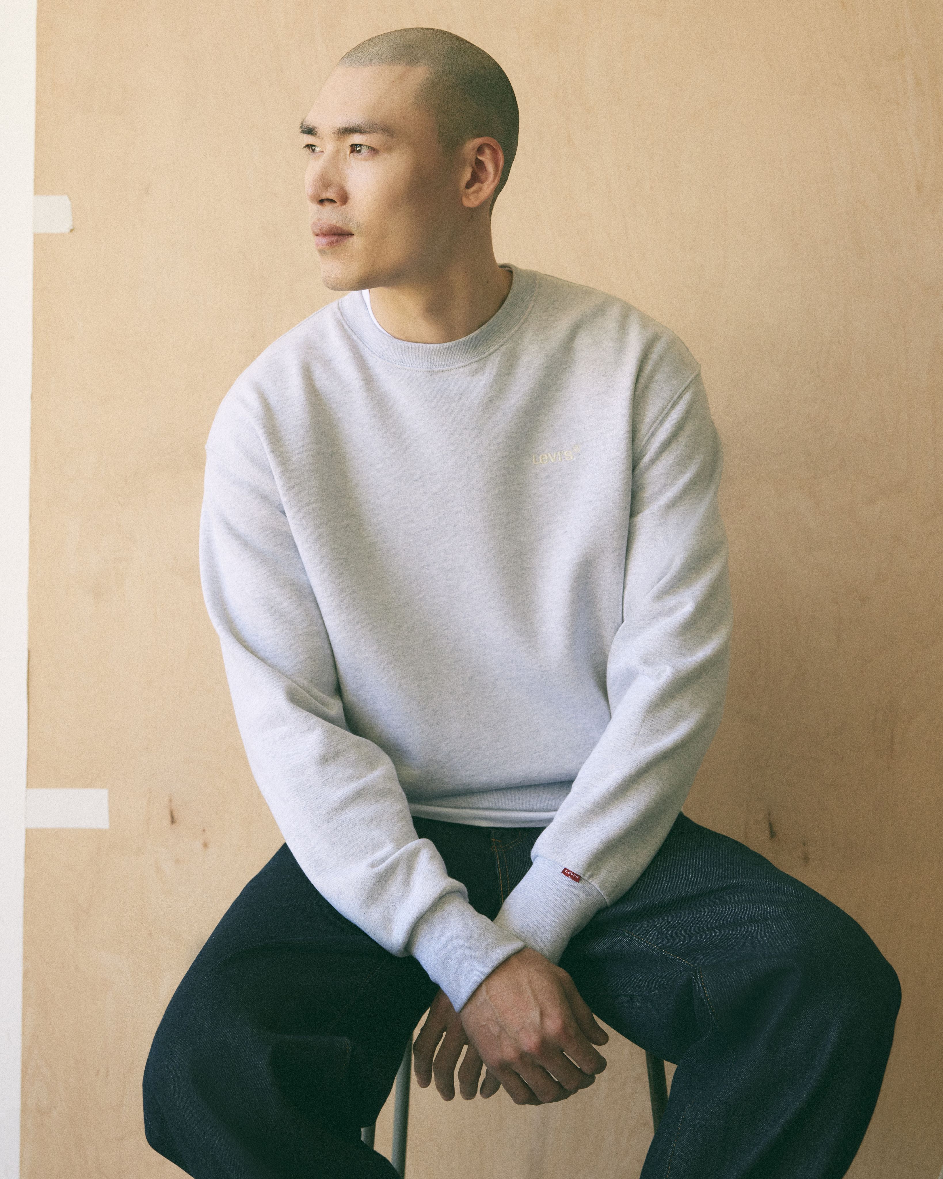 Male model wearing a green sweatshirt.