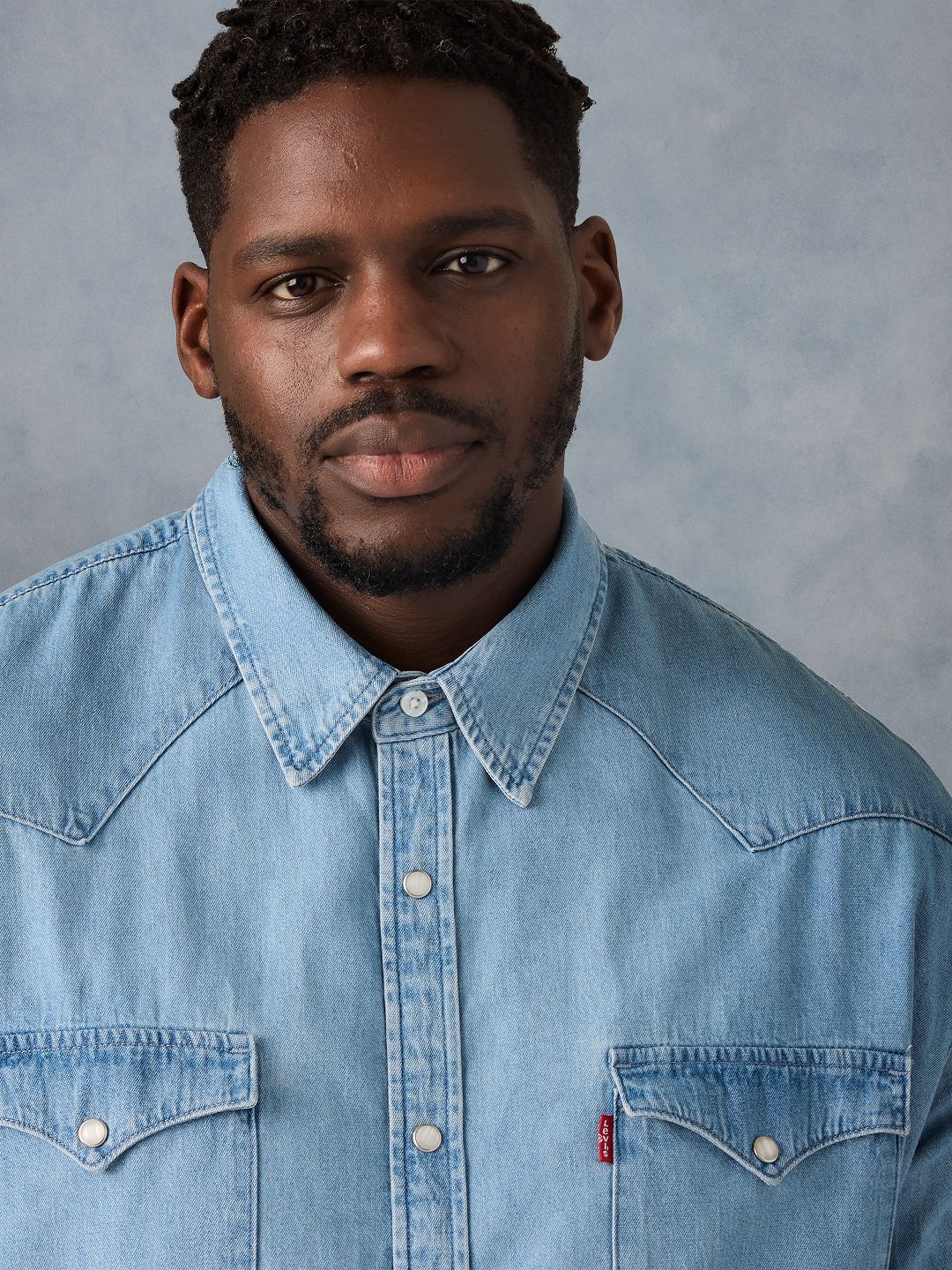 Model wearing black tee with white Levi's logo on the chest.