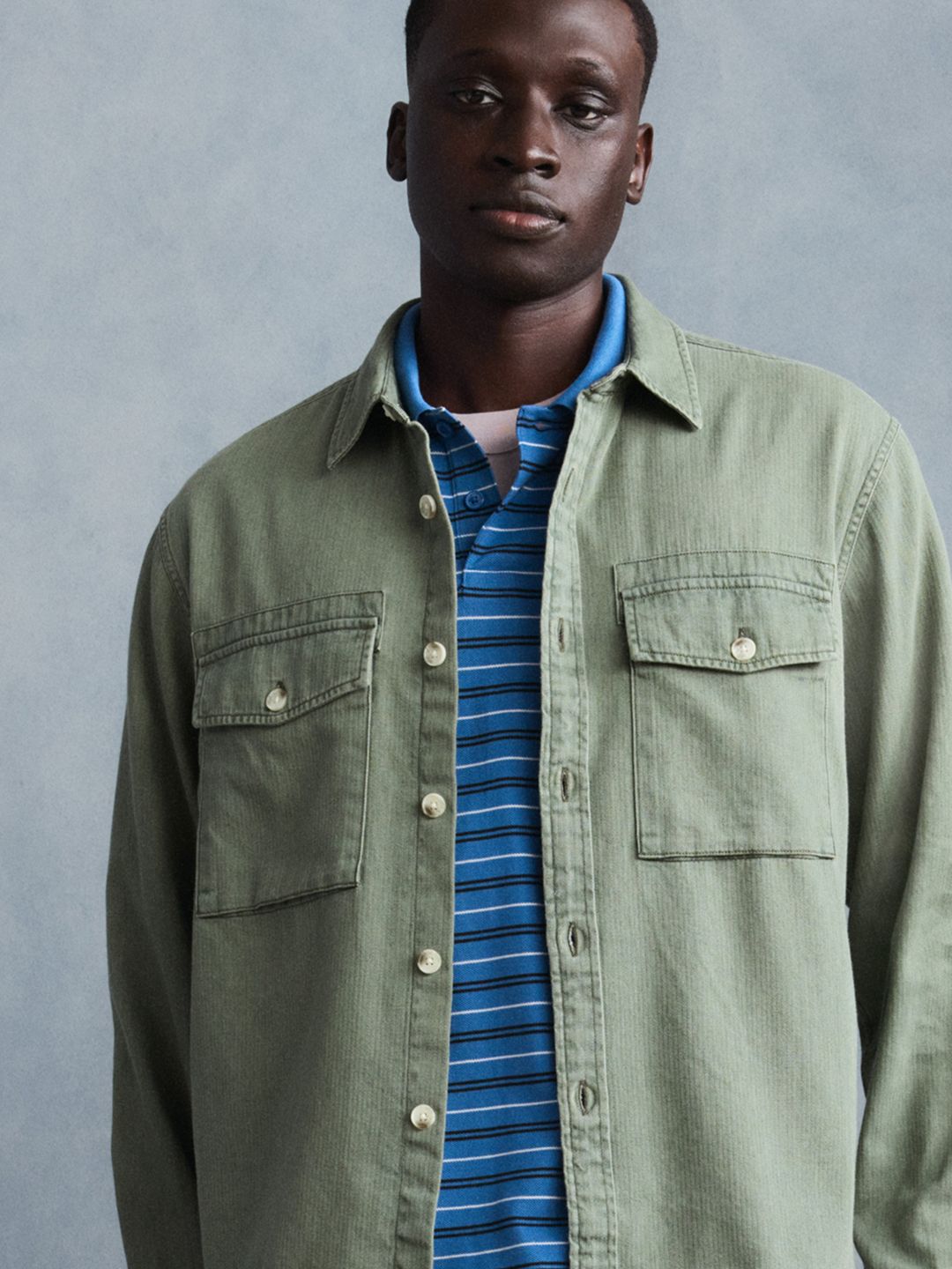 Model wearing black short-sleeve button-up shirt.