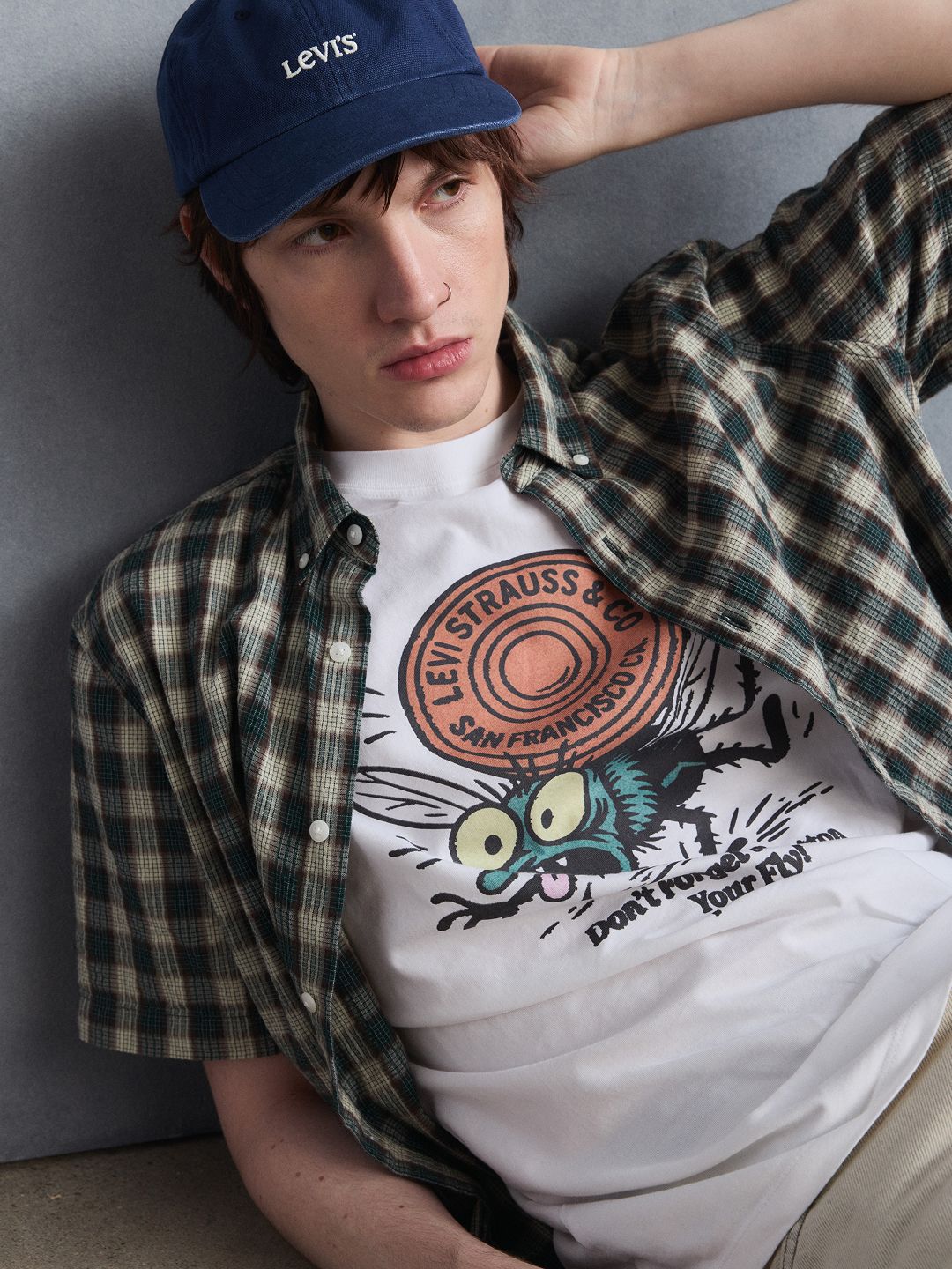Model wearing white graphic t-shirt.