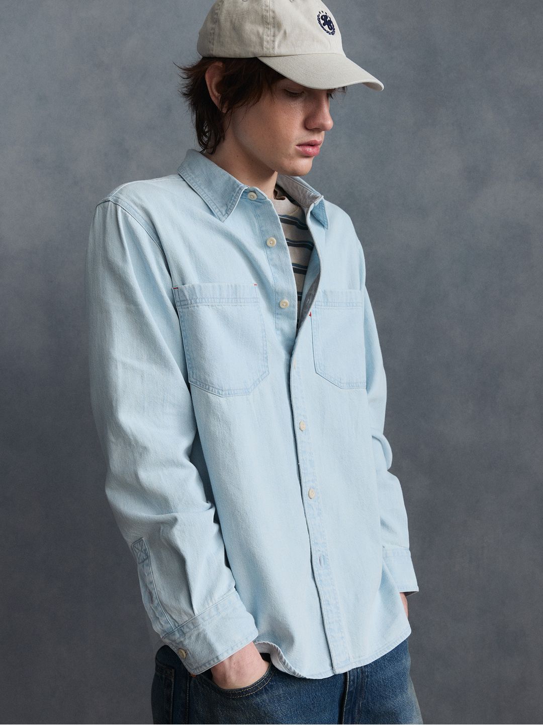 Model wearing light wash denim long-sleeve top.
