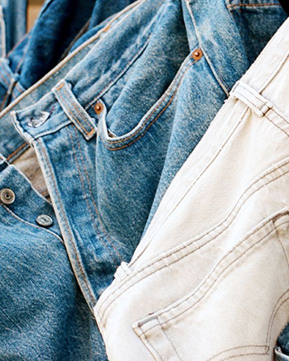 An image of different jeans hanging up