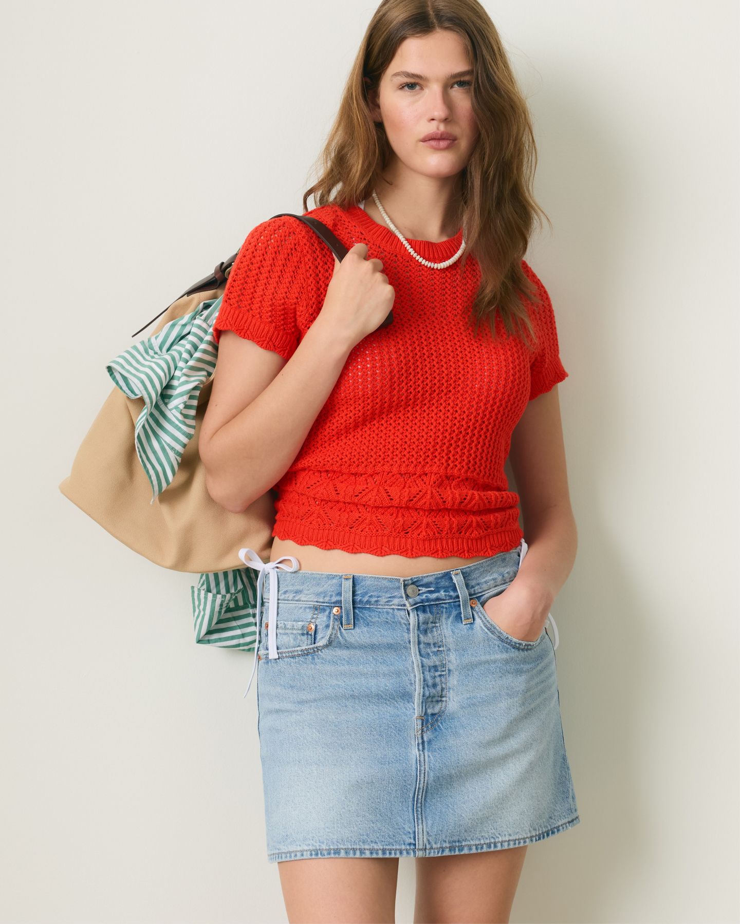 model wearing red top and denim skirt